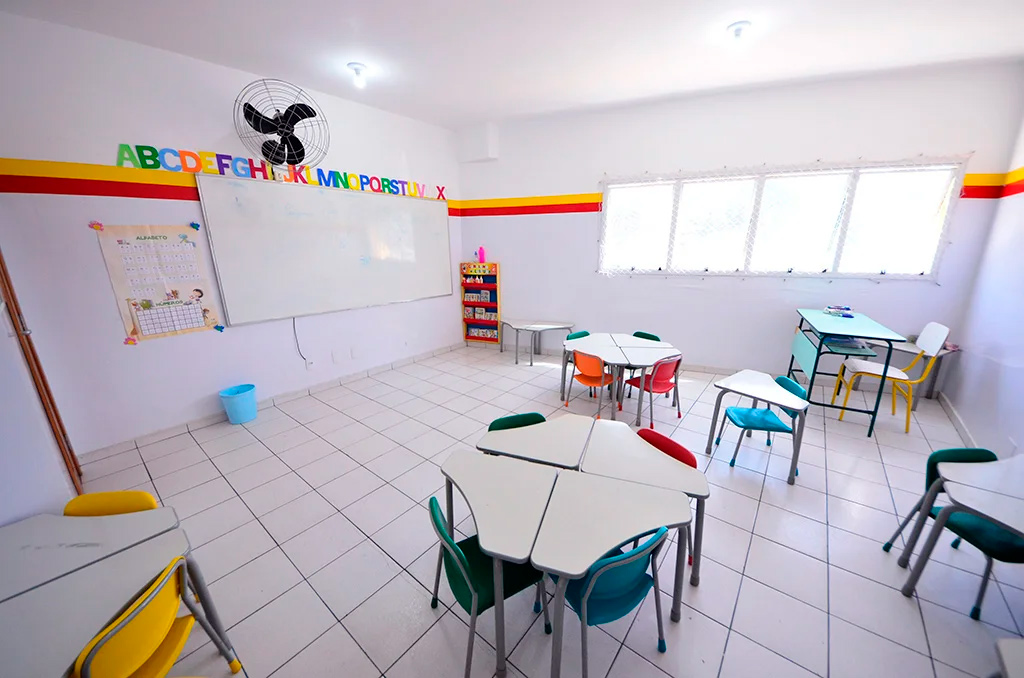 Sala com mesas em grupo para atividades colaborativas